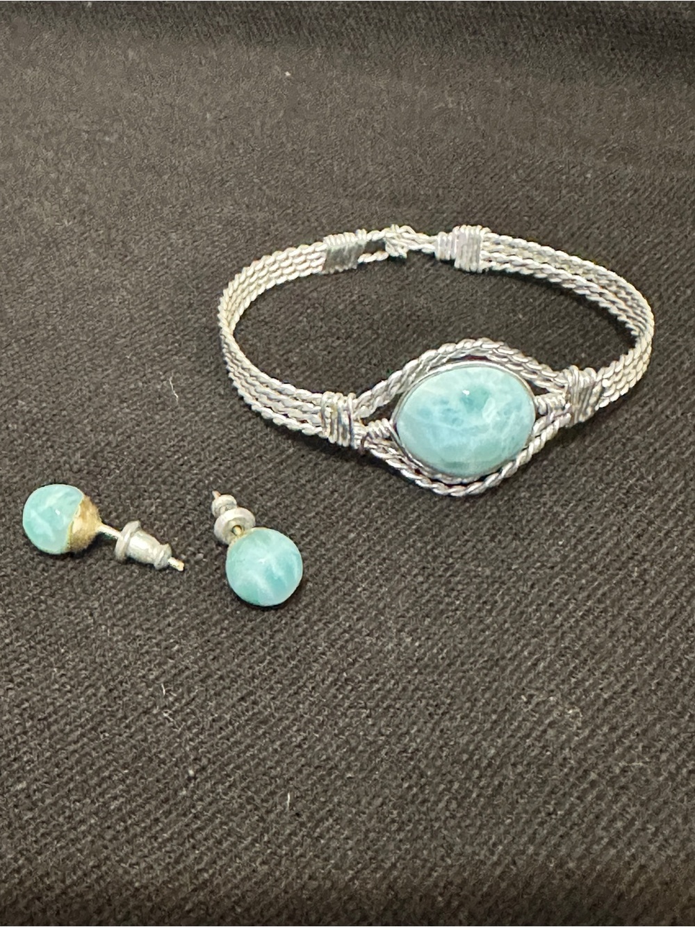 Handcrafted wire-wrapped bracelet featuring a light blue oval larimar gemstone